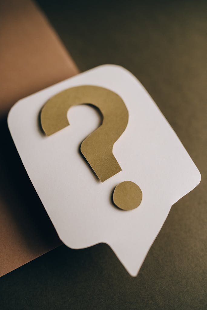 Artistic paper craft of a question mark symbol on a textured green surface. Ideal for conceptual projects.